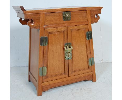 A vintage 20th century Chinese hardwood altar table having a flared top with a single drawer over twin doors opening to revea