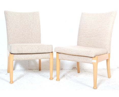 A pair of vintage Parker Knoll chairs having a beige upholstery to the seat and backrest raised on turned beech wood legs. Me