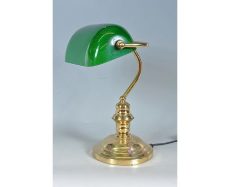 A 20th Century vintage bankers desk / table lamp light of brass construction having an adjustable green glass shade supported