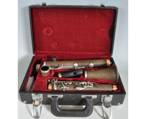 A vintage 20th century clarinet musical instrument having a dark green finish. Comes with four reeds. Disassembles for ease o