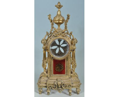 A mid 20th century French antique style brass rococo mantel clock case. The case having a large finial to the top flanked wit
