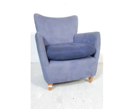A vintage retro 20th century easy chair / armchair having curved backrest with shaped armrests, detachable cushion raised on 