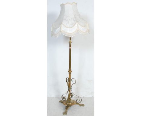 An early 20th century 1920s brass standard lamp converted oil lamp having a splayed tripod base with animal feet. Comes with 