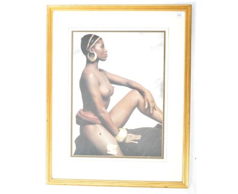 A retro vintage 20th Century 1980's framed and glazed portrait photograph depicting a nude women in a seat position adorned w