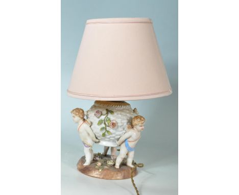 A 19th Century German Sitzendorf floral encrusted winged cherub / putti porcelain oil lamp set over a floral spray embellishe