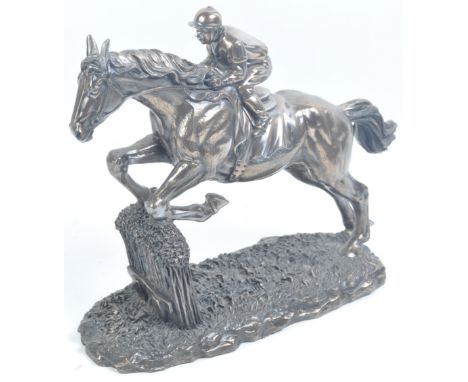 Horse Racing - a 20th century bronze effect resin composite statue of a horse and jockey approaching a fence. Well detailed e