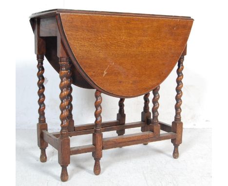 An early 20th Century 1920's antique oak barley twist gate leg table having an oval top raised on barley twist legs united by