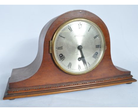 A 20th Century antique Camerer Cuss &amp; Co Napoleon's hat mantel clock having a mahogany case with a round face with a cham