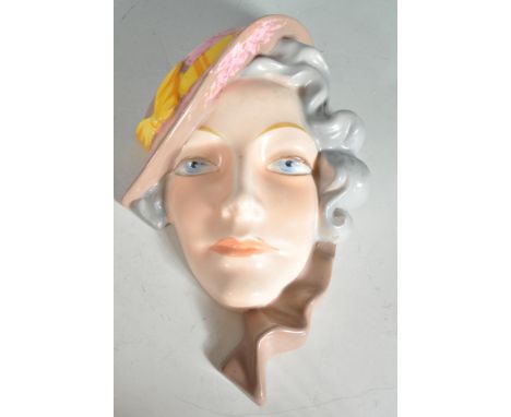 An early 20th Century Art Deco Czechoslovakian ceramic wall plaque in the form of a female figure with a tilted hat, with han