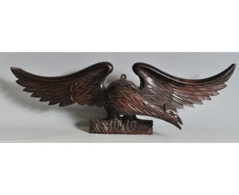 A vintage antique style 20th century carved stained pine eagle pediment. The eagles features are in profile and is perched on