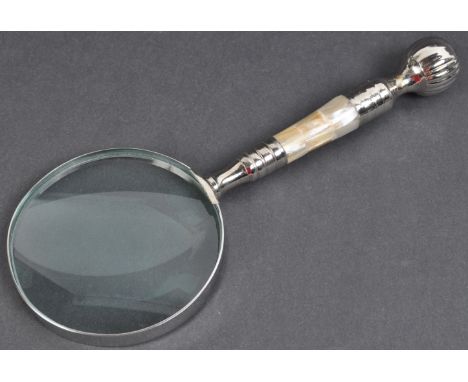 A 20th Century desktop magnifying glass having a large round lens set within white metal set with a mother of pearl handle. M