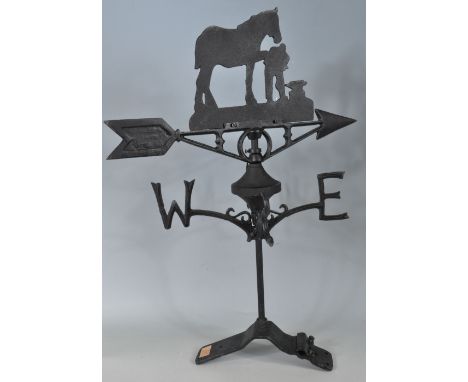 A vintage style contemporary cast iron ebonised weather vane having a wind direction arrow in the form of a&nbsp; farrier sho