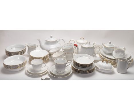 A vintage Chodziez Polish china tea service having a white ground with gilt rims, includes tea pot, hot water pot, cups, sauc
