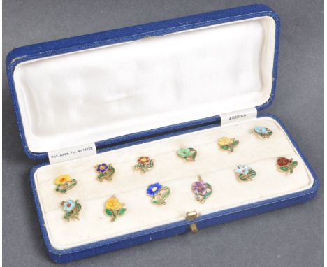 A cased set of early 20th c1920s century gilt sterling silver and enamel cup tokens / markers. Each in the form of a differen