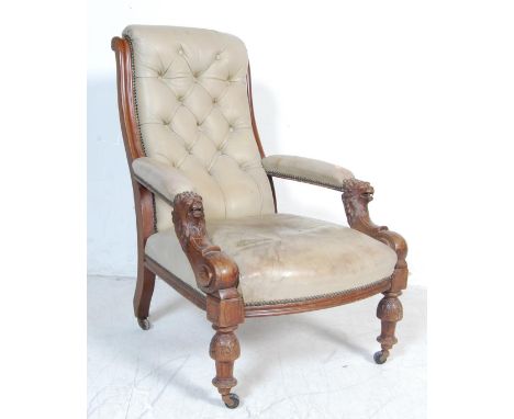 An early 20th century mahogany button back library chair / easy chair / arm chair&nbsp; having carved lion handles with geome