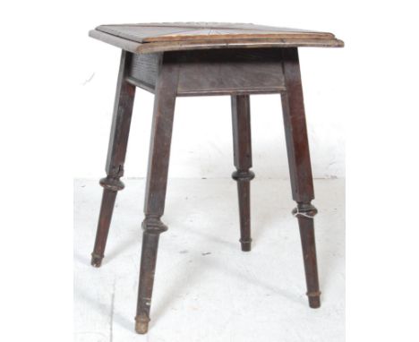 An early 20th Century Arts and Crafts heavily carved oak side table / lamp occasional table having a sunburst carved squared 