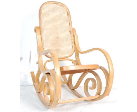 A vintage 20th Century bentwood and cane rocking chair / armchair / rocker in the manner of Michael Thonet having scrolled an