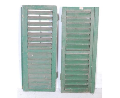 A pair of early 20th century continental Italian wooden shutters for a rectangular form with adjustable flaps and periodic me