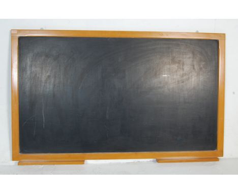 A large vintage late 20th century school chalkboard of rectangular form set within a wooden frame having two chalk holders to