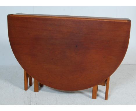 A retro 1970's teak wood Danish influenced G-Plan drop leaf dining table raised on shaped supports with full length drop leav