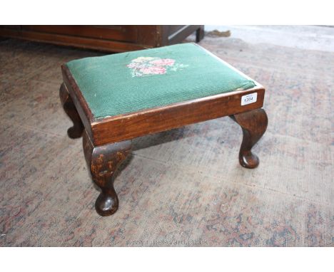 A Footstool with green and floral tapestry, standing on cabriole legs