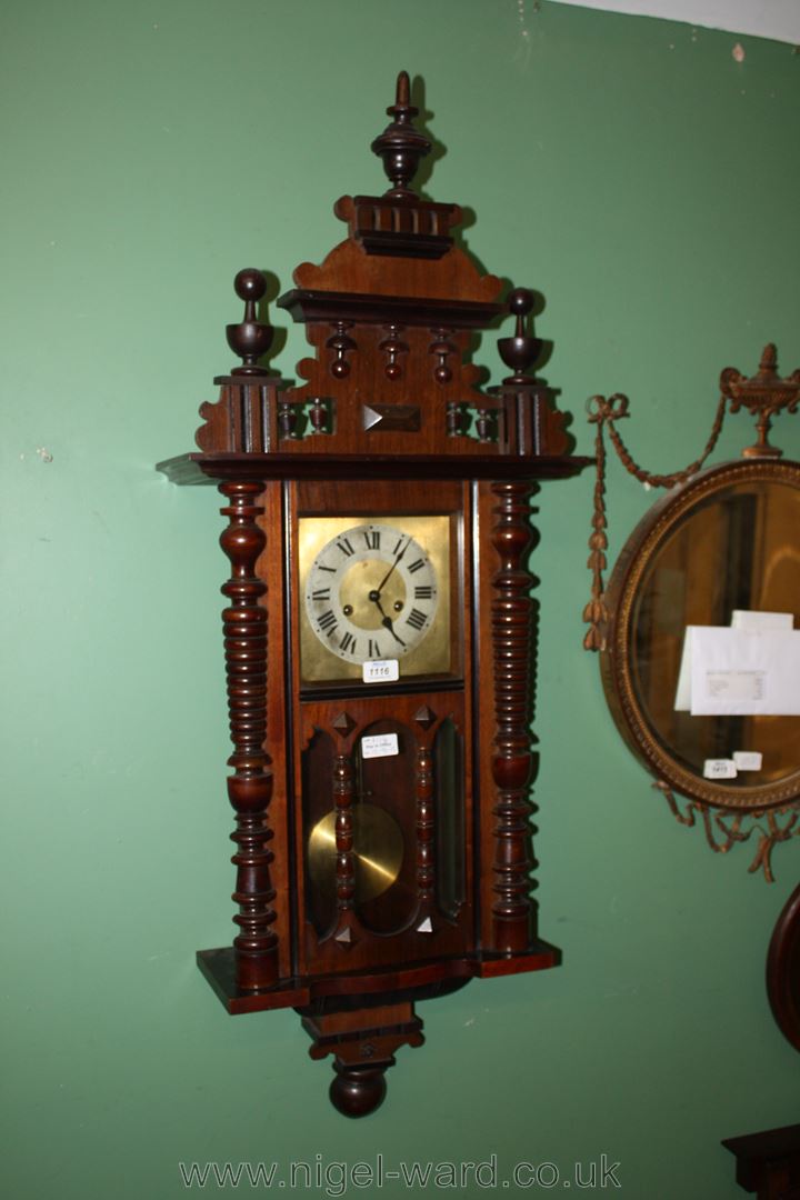 A Vienna style Wall Clock with turned decoration, turned decorative pediment and base, complete w