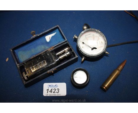 An electric 4 in 1 Truscale Meter, the scale reading 6/15/150 volts and 0-30 milliamps, 2'' diameter; a used rifle round, a 1