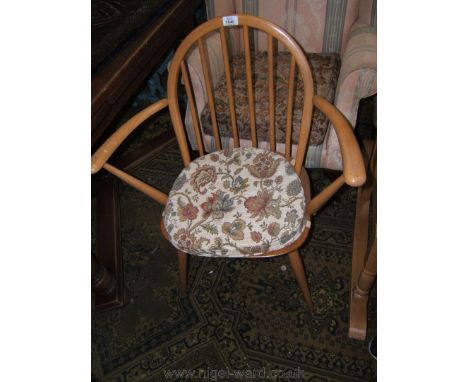 An Ercol 'Golden Dawn' carver Chair having Beech hoop stick back, Beech arms, Oak seat and standing on turned tapering legs.