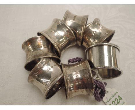 A set of six silver napkin rings of plain form, Birmingham 1945, (1 AF), and a white metal napkin ring stamped silver,  appro