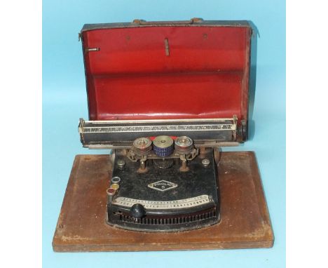 A 'Frolio 5' typewriter with lacquered metal cover.