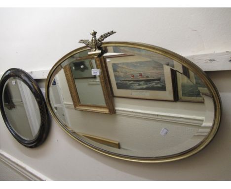 Early 20th Century oval brass framed bevelled edge wall mirror with floral surmount 