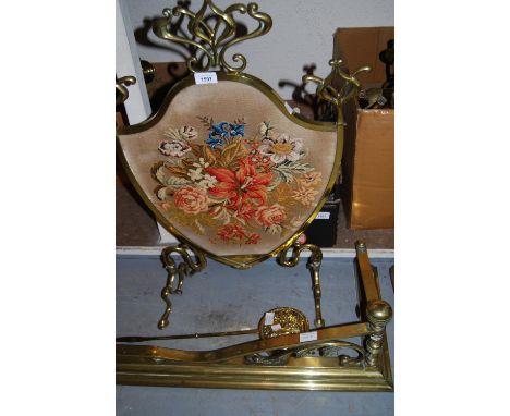 Victorian brass shield shaped firescreen with a needlepoint insert together with a brass fireplace fender and a brass chestnu
