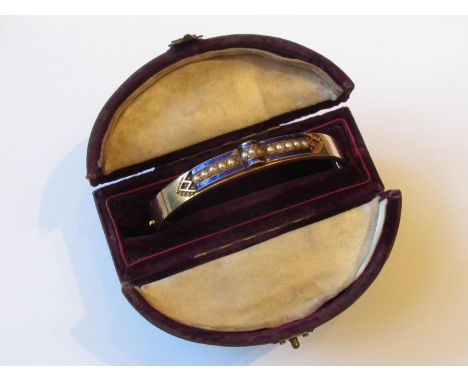 Victorian gold bangle, blue enamel decorated and set with a band of seed pearls, boxed 