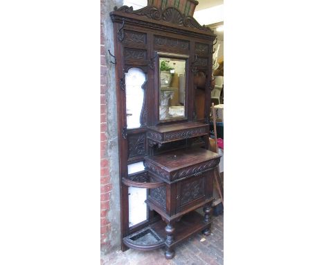 Victorian carved oak hallstand, the bevelled mirror inset back with wrought iron hooks above two drawers and a central cupboa