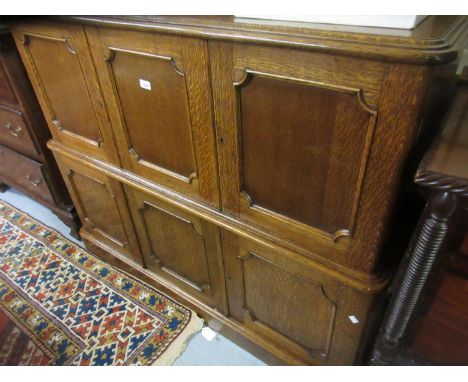 Victorian oak buffet cabinet having galleried back with central carved shield above two tiers of shaped panel doors, on a pli