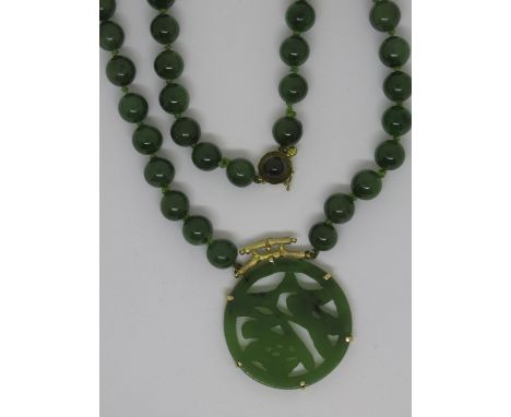 Chinese 14ct gold  mounted jade pendant suspended from a bead necklace 