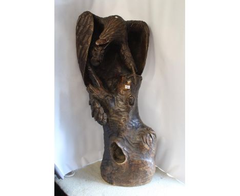 Large carved wooden figure of an eagle with prey, on naturalistic tree trunk (carved from one piece, at fault), 50ins high 