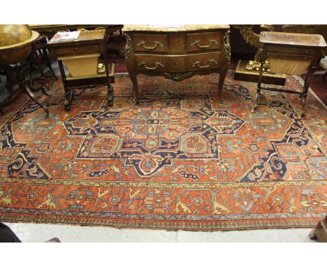 Antique Heriz carpet with a typical medallion and all-over stylised floral design on a brick red ground with borders, 12ft 6i