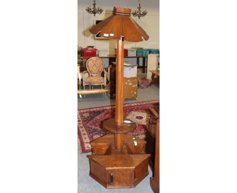An Art Deco oak standard lamp with slatted shade on magazine rack and cupboard base, 177cm high