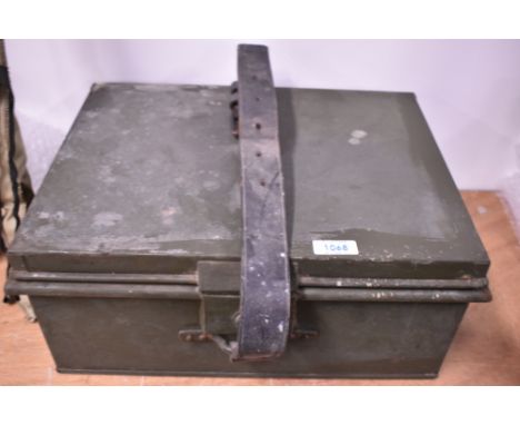 A green military style ammunition box with leather strap and key