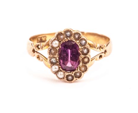 An antique gold and gem set ring, having a cut pink stone surrounded by seed pearls on 9ct gold band with split shoulders 