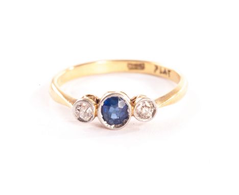 An Edwardian three stone diamond and sapphire ring, the round cut blue stone flanked by two old cuts in platinum rubbed over 
