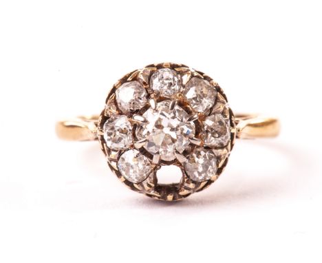 An Edwardian diamond dress ring, the circular tablet centred with an old cut stone and surrounded by smaller examples, one se