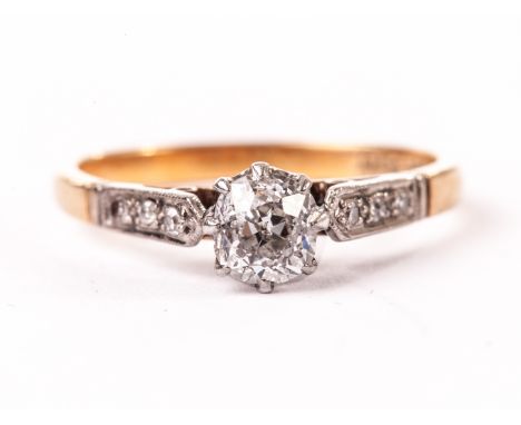 An Edwardian diamond engagement ring, having an old cut stone in platinum claws and platinum shoulders each set with three sm