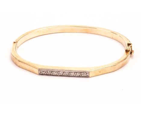 A Middle Eastern yellow metal and diamond bangle, the eight small brilliant cuts set in white metal on bangle marked 14k 