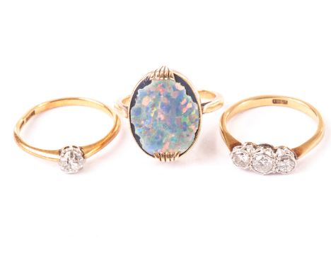 A vintage three stone diamond ring, together with a solitaire diamond ring, both marked 18ct, and an opal and yellow metal ri