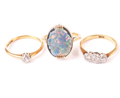 A vintage three stone diamond ring, together with a solitaire diamond ring, both marked 18ct, and an opal and yellow metal ri