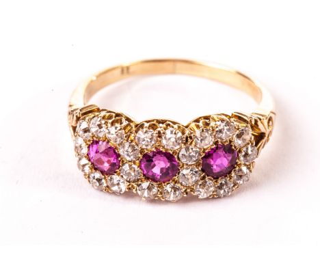 A pretty Edwardian ruby and diamond dress ring, in 18ct gold mount having split engraved shoulders and the tablet of three ci