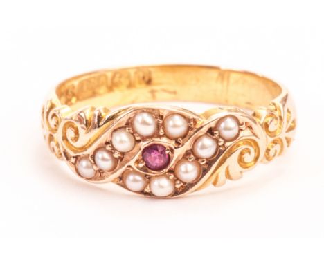 A Victorian 15ct gold dress ring, the crossover style tablet set with seed pearls and centred with a red cut stone 