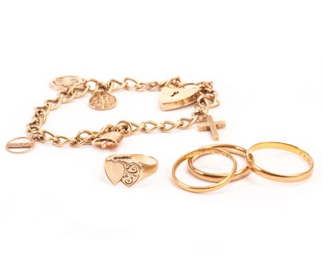 A 9ct gold charm bracelet and four gold ring, including the several charms to curb link chain, a 9ct gold wedding band, two w